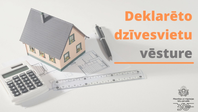 Maza mēroga mājas makets uz galda, blakus kalkulatoram un lineālim