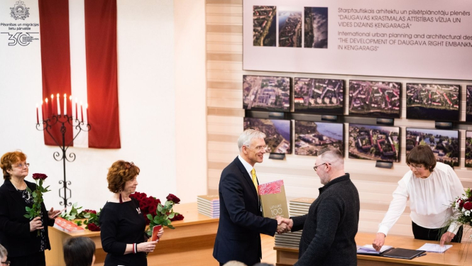 Premjerministrs Arturs Kariņš sveic cilvēku, kurš kļuva par Latvijas pilsoni naturalizācijas kārtībā