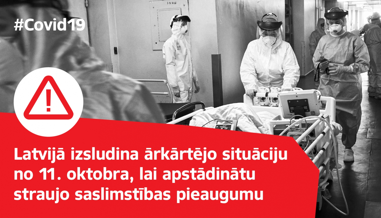 Melnbalta bilde ar ārstiem aizsargtērpos slimnīcas koridorī