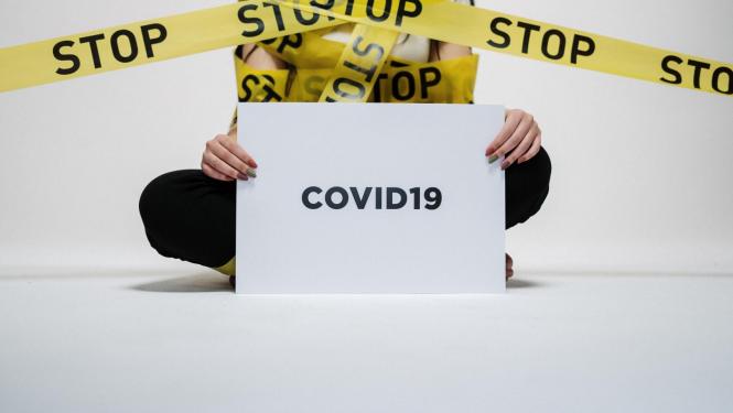 Dzeltenās lentes ar uzrakstu STOP Covid 19 izplatības ierobežošanai