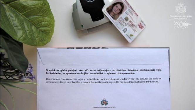 PIN kodu aploksne, eID karte un viedkāršu lasītājs uz galda