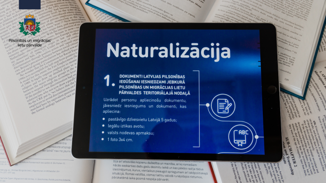 Planšetdators un uz tā vizuālais attēls ar uzrakstu "Naturalizācija"