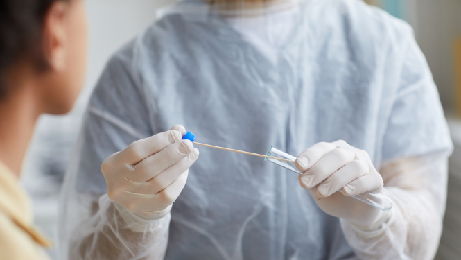 Cilvēks medicīniskajā formā ņem testu uz Covid-19