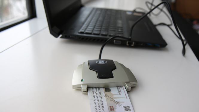 E-parakstītājs ar eID karti, blakus portatīvajam datoram