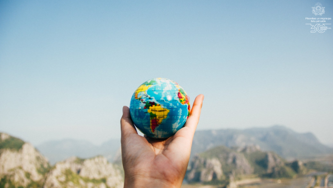 Rokā tur mazu globusu