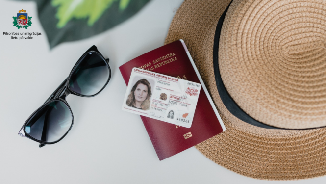 uz galda: pase, eID karte, saulesbrilles, saules salmu cepure