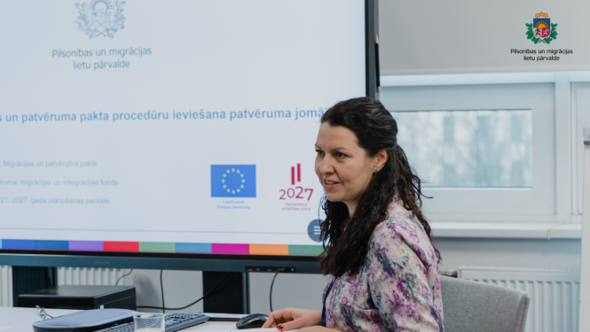 ES projekta vadītāja sēž pie galda, un prezentē projektu