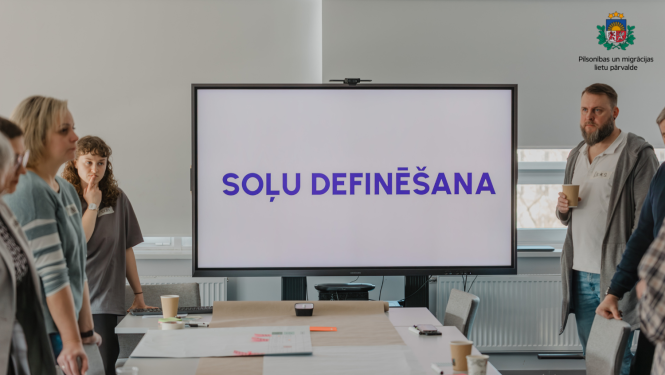 PMLP darbinieki stāv pie ekrāna, uz  kura ir uzraksts "Soļu definēšana"