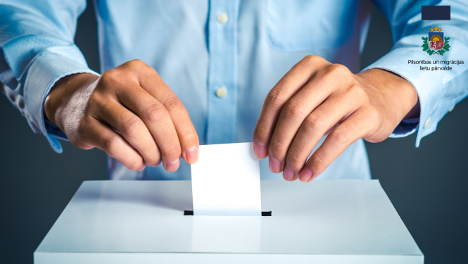 Cilvēka gaiši zilajā kreklā rokas, kas met aploksni vēlēšanu urnā 