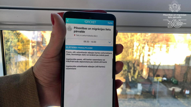Mobilais telefons rokās ar atvērtu Qticket programmu un iespēju veikt pierakstu PMLP talsu nodaļā