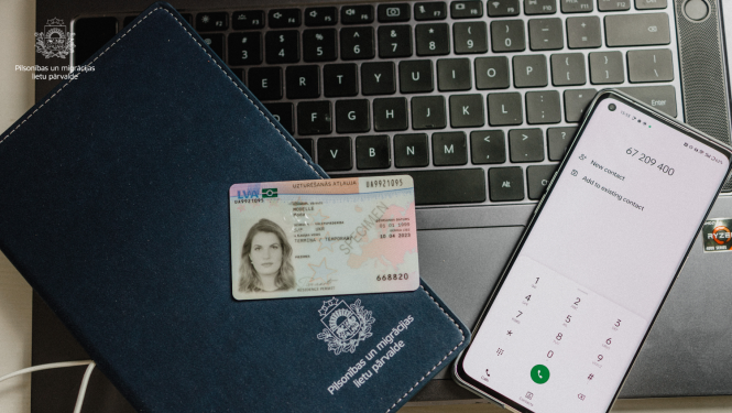 uzturēšanās atļaujas ID karte uz datora klaviatūras fona