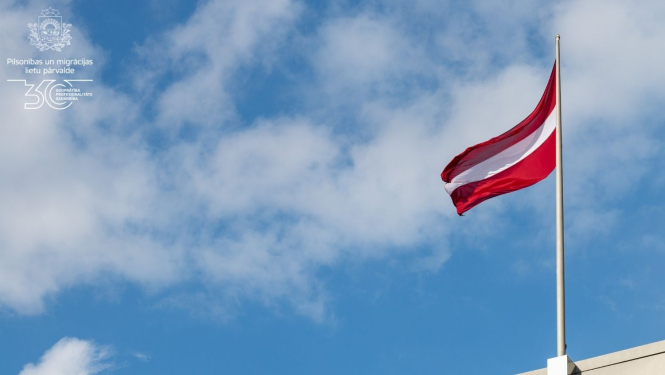 Latvijas karogs, kas plīvo zilajās debesīs 