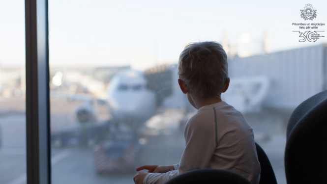 Bērns skatās pa logu lidostā