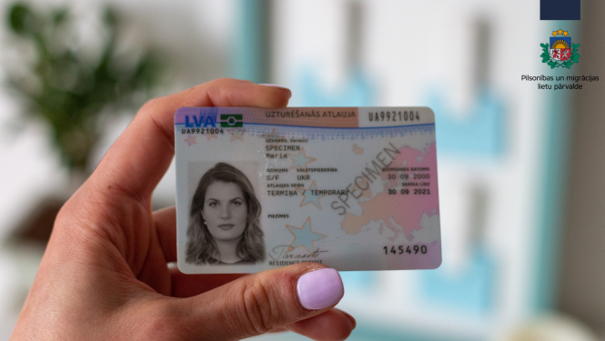 Uzturēšanās atļaujas karte sievietes rokā