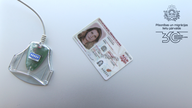 Uz galda ID karte un viedkāršu lasītājs 