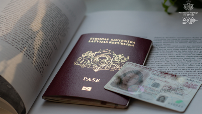 Uz atvērtas grāmatas ir Latvijas pilsoņa pase un eID karte