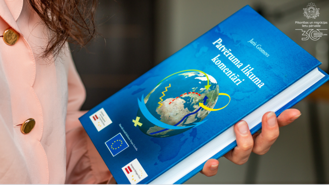 Sieviete tur rokās grāmatu "Patvēruma likuma komentāri"