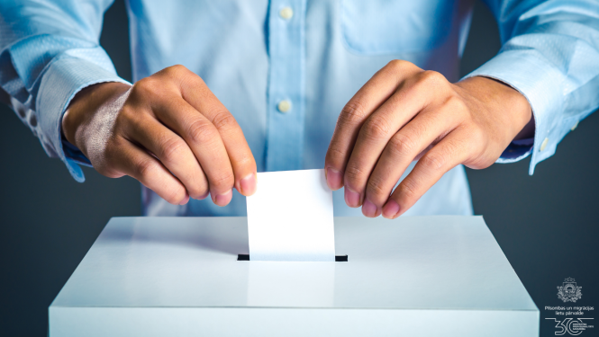 Cilvēka rokas, kas met aploksni vēlēšanu urnā