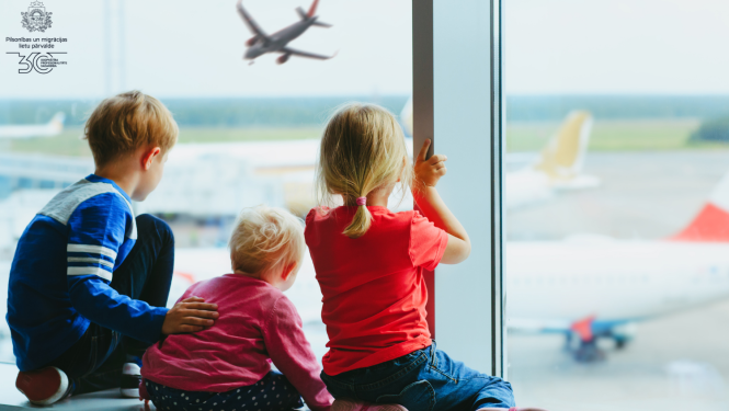 bērni lidostā skatās uz aizlidojošu lidmašīnu