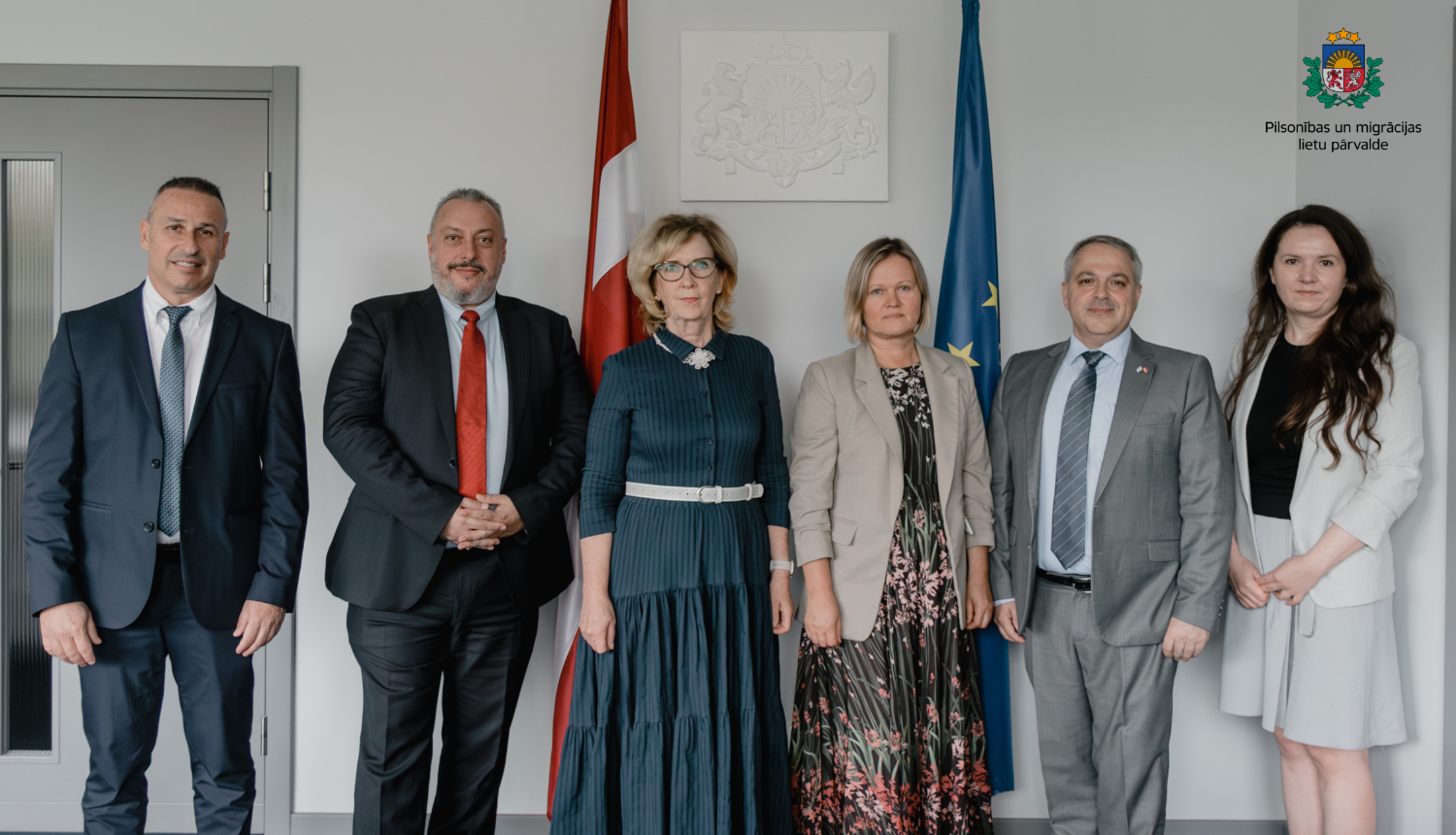 Pārvaldes pārstāvji stāv blakus Izraēlas delegācijas pārstāvjiem. Fonā - Latvijas karogs.