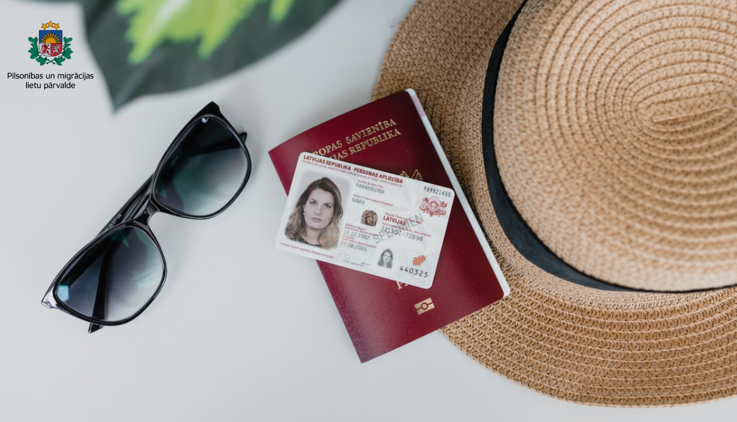 uz galda: pase, eID karte, saulesbrilles, saules salmu cepure