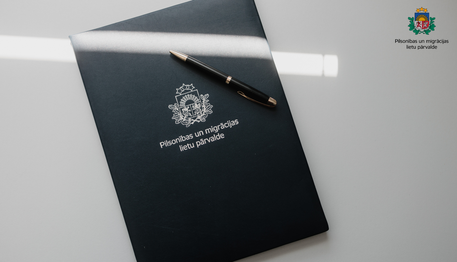 Grāmata ar PMLP logo un pildspalvu