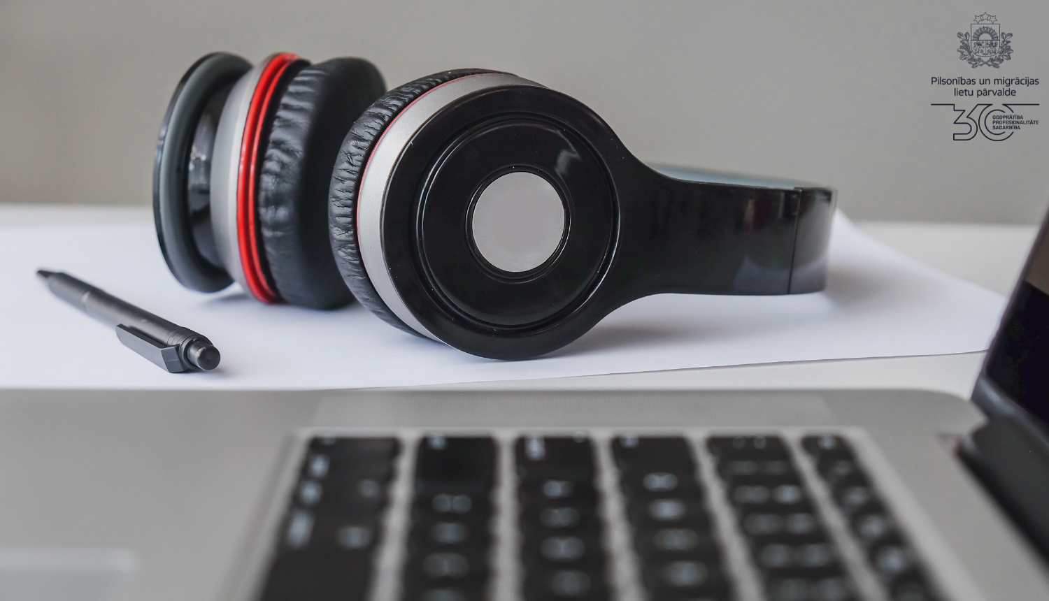 Austiņas uz galda blakus datora tastatūrai