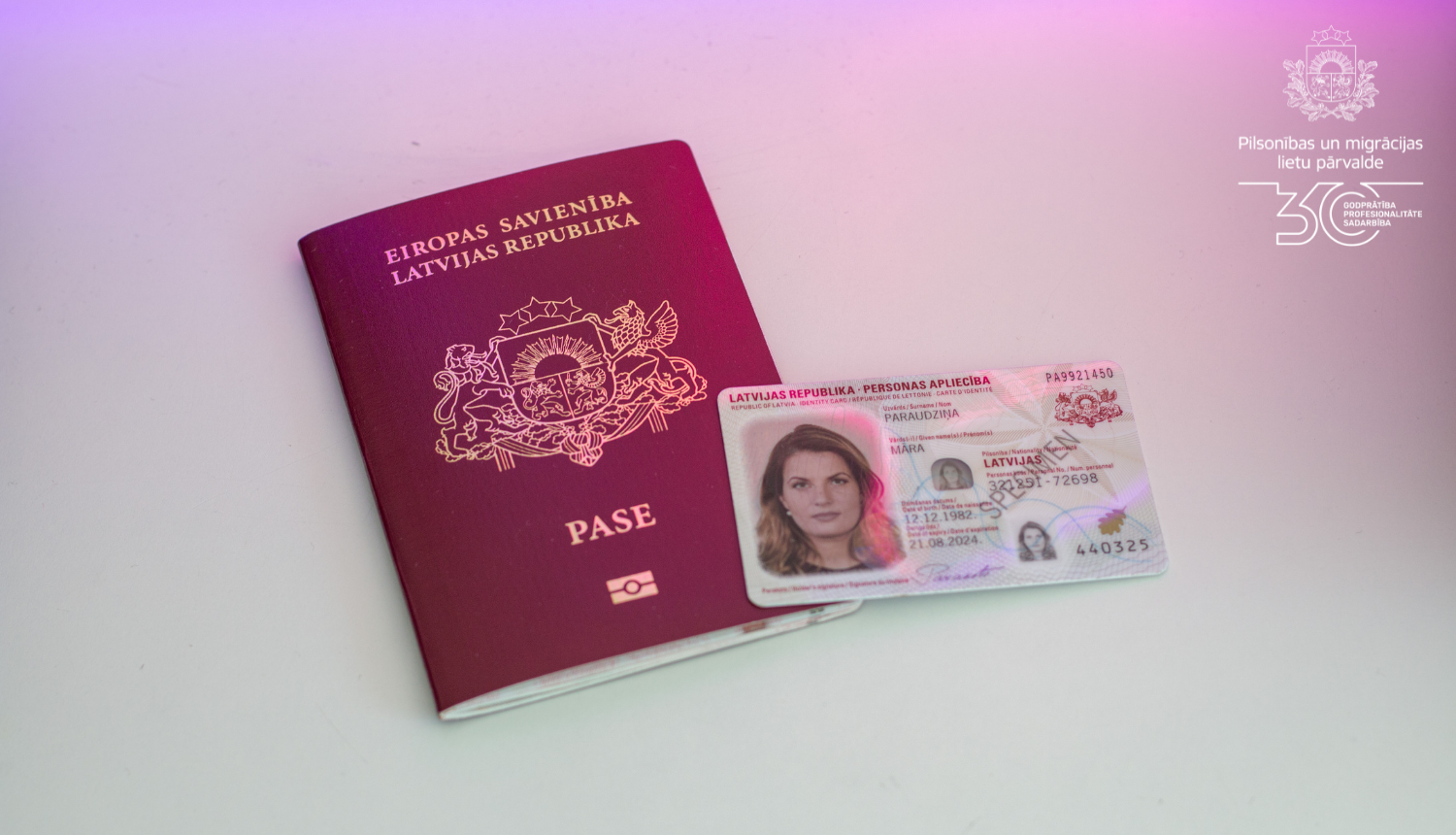 Uz galda fotogrāfija ar pasi un eID karti