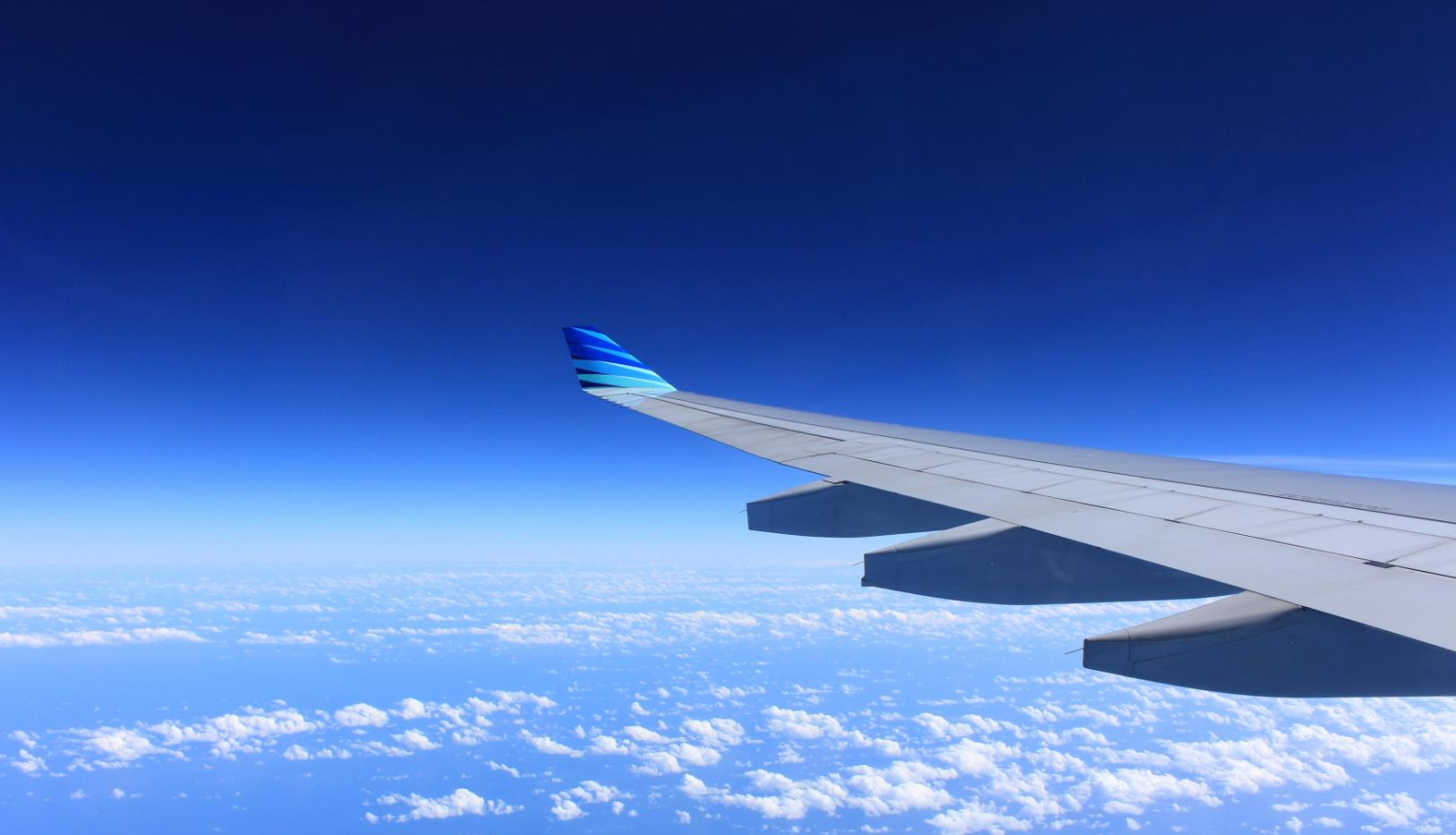 Lidmašīnas spārns zilajās debesīs