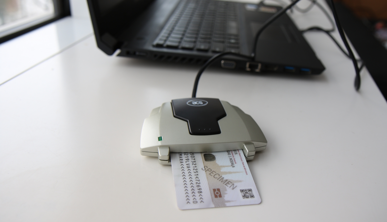 E-parakstītājs ar eID karti, blakus portatīvajam datoram
