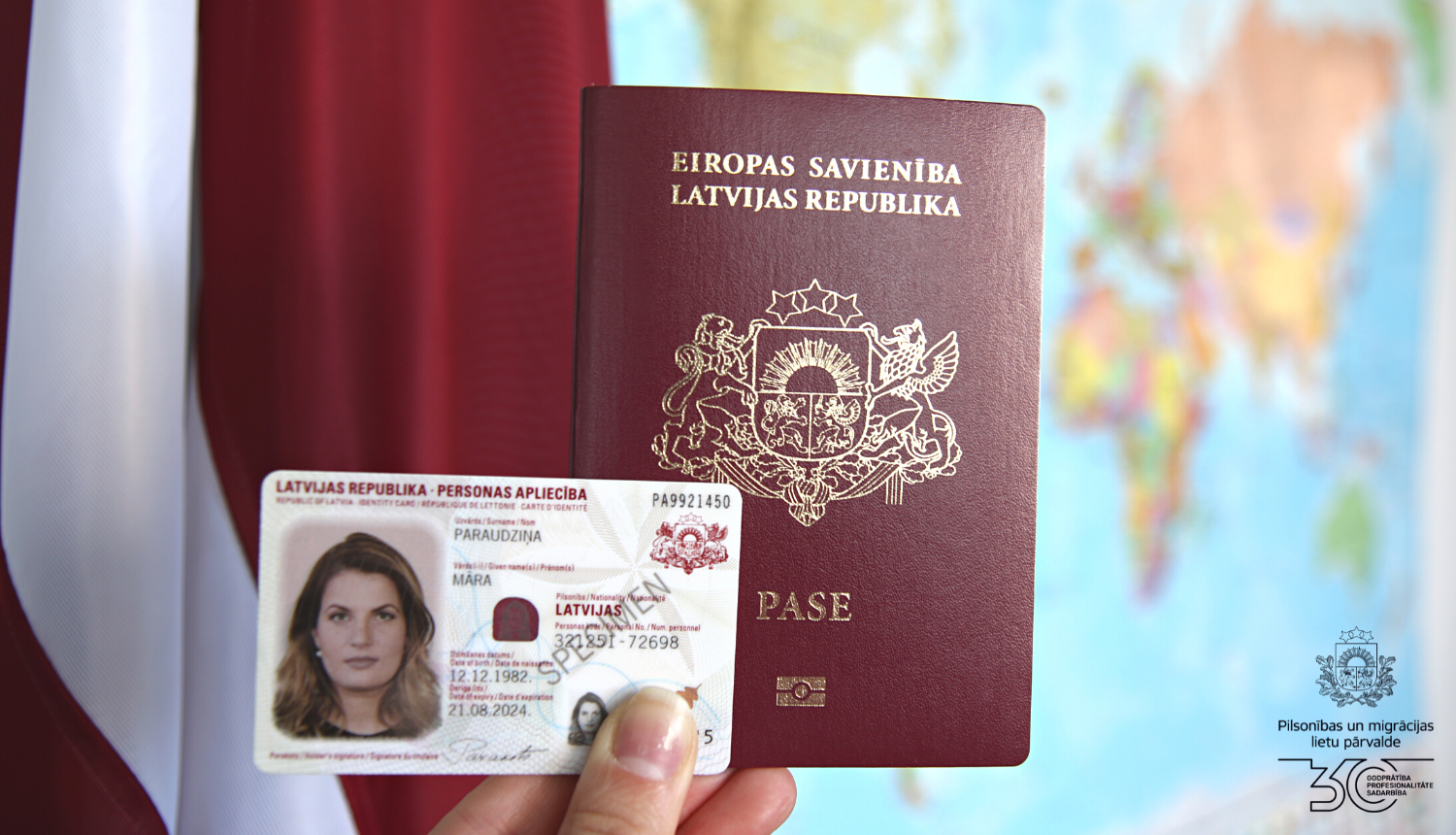 Uz Latvijas karoga fona: pase un eID karte