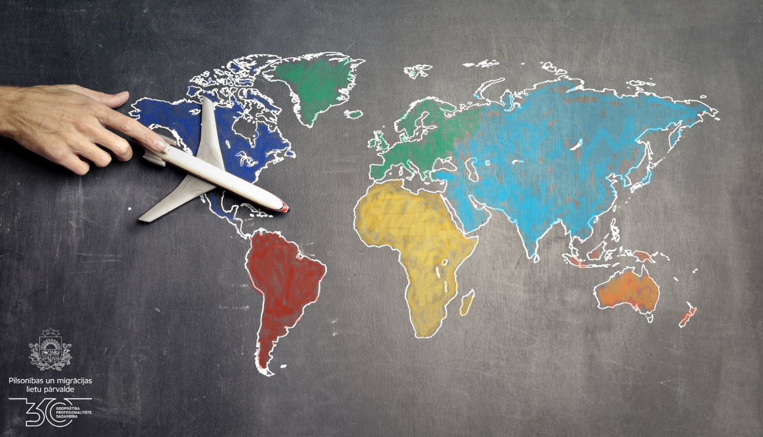 Grafiski attēlota pasaules karte, pa virsu nofotagrafēta cilvēka roka ar mazu rotaļlietu - lidmašīnu